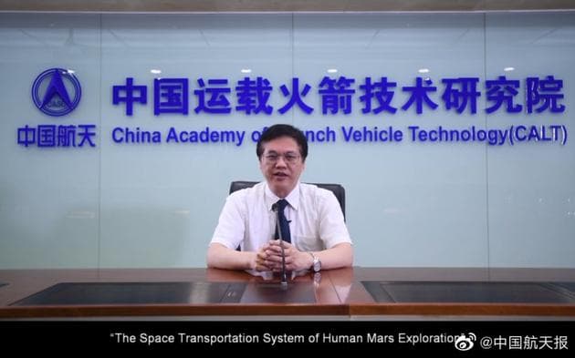 A frame of 王小军 (Wang Xiaojun), president of the China Academy of Launch Vehicle Technology, delivering his plenary report by video link, seated at a table in front of the CALT sign reading 中国运载火箭技术研究院 and China Academy of Launch Vehicle Technology (CALT), with the subtitle "The Space Transportation System of Human Mars Exploration" across the bottom.