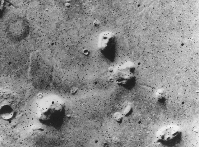 The image that started everything, in the form JPL released it on 31 July 1976. Viking 1 orbiter frame 035A72 was taken at 15:25:14 GMT on 25 July 1976 through the clear filter with a 34 millisecond exposure, from a range of 1873 km, while the mission was surveying landing sites for Viking 2. Published pixel scales for the frame differ: the mission's ancillary record says 46 m, the Malin Space Science Systems catalogue table says 47 m, and Carlotto's 1988 paper says 51.73 m, so a feature the release measured at 1.5 km across is roughly thirty pixels wide. NASA's Photojournal caption for this same picture states that the speckling is missing data called bit errors caused by problems in transmitting the data from Mars to Earth, and that those bit errors comprise part of one of the eyes and one of the nostrils. What is reproduced here is a subframe of the full 1204 by 1056 pixel frame, printed larger than the data: the 1976 release itself says the speckled appearance is emphasized by enlargement of the photo, and the Face spans about sixty pixels in this 640 by 472 file against roughly thirty in the original sampling. Several other eroded mesas of the same family sit in the frame and none of them reads as a face.