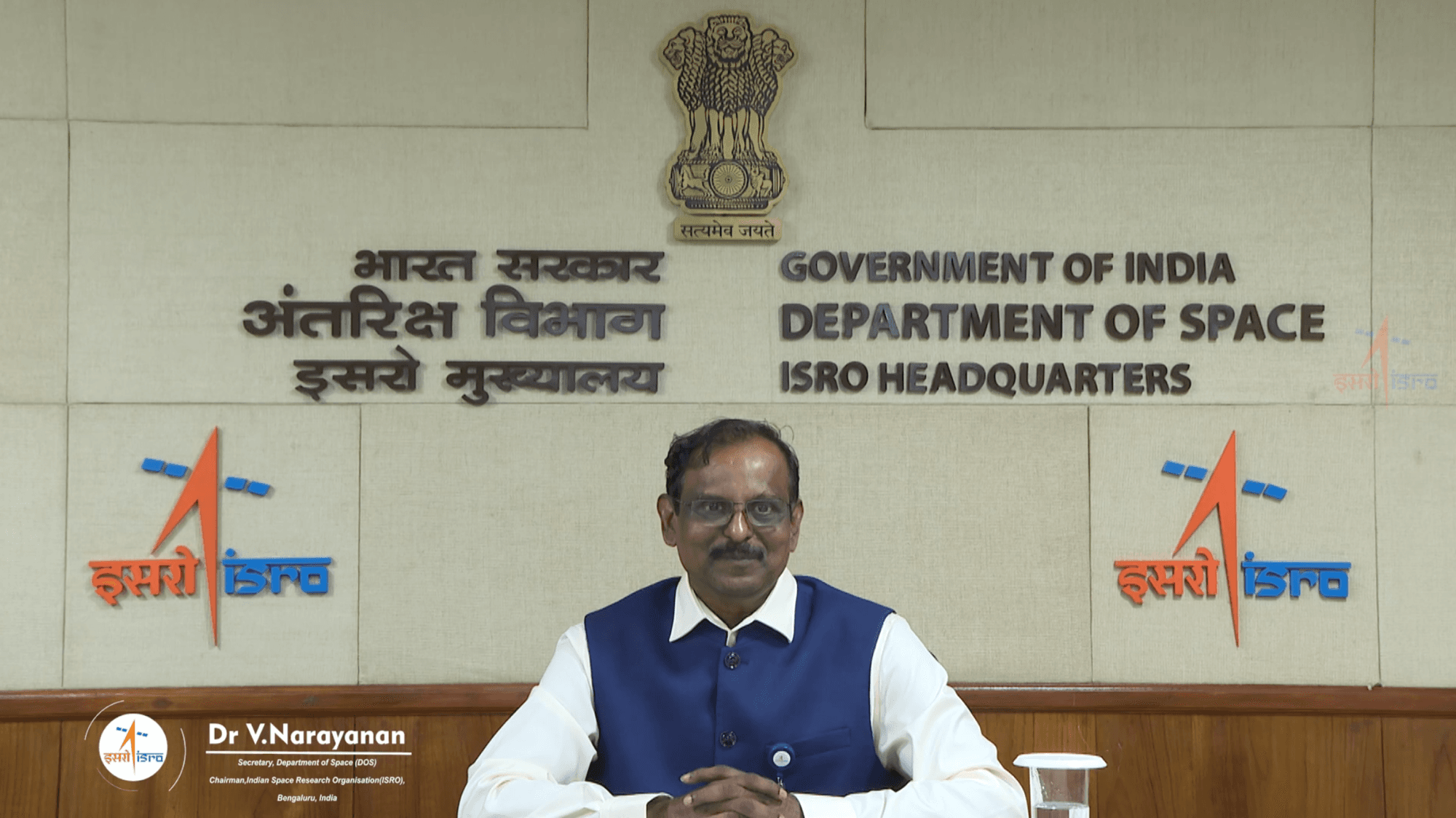 Dr V. Narayanan seated at ISRO Headquarters in Bengaluru on 15 January 2025, the day ISRO announced he had begun functioning there, beneath the State Emblem of India and the wall lettering 'Government of India, Department of Space, ISRO Headquarters' in English and Hindi. The frame carries ISRO's own on-screen caption naming him Secretary, Department of Space and Chairman, ISRO.