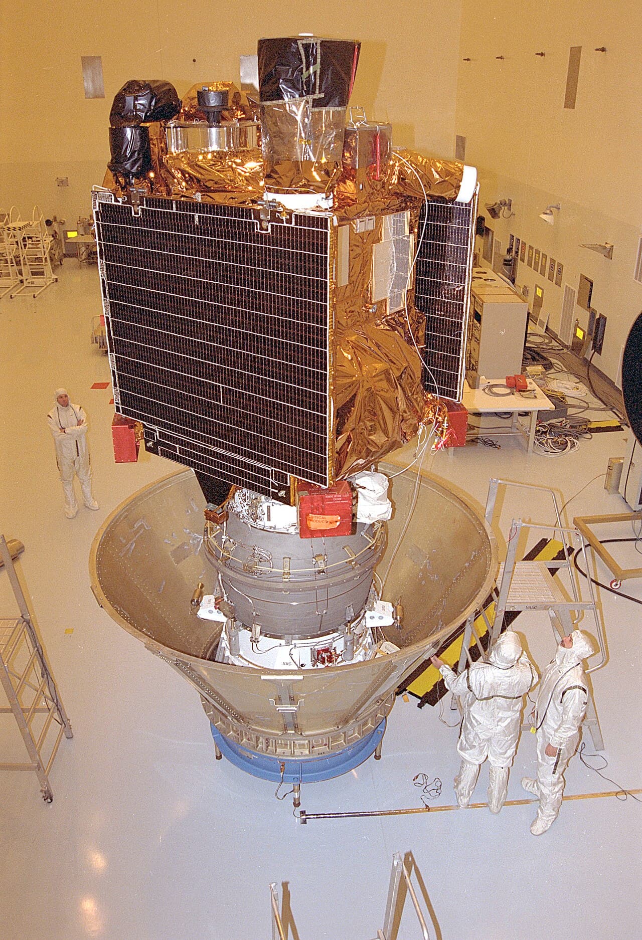 Jet Propulsion Laboratory workers in the Payload Hazardous Servicing Facility at Kennedy Space Center prepare Mars Global Surveyor, already mated to its solid propellant upper stage, for transfer to the launch pad on 21 October 1996.