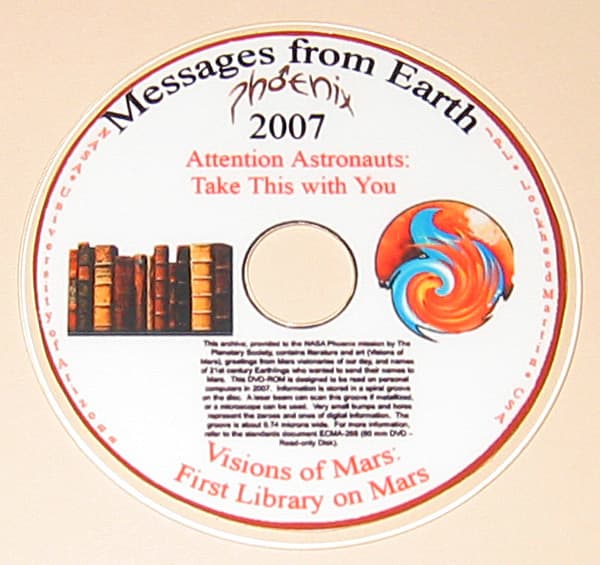 The silica glass mini-DVD photographed against a plain background on Earth, its label reading Messages from Earth, Phoenix, 2007, Attention Astronauts: Take This with You, and at the foot Visions of Mars: First Library on Mars, with a painting of a row of old books at the left, a swirled Mars motif at the right, a paragraph of explanatory text below the hub, and the names of the University of Arizona, Lockheed Martin, NASA and JPL running around the rim.