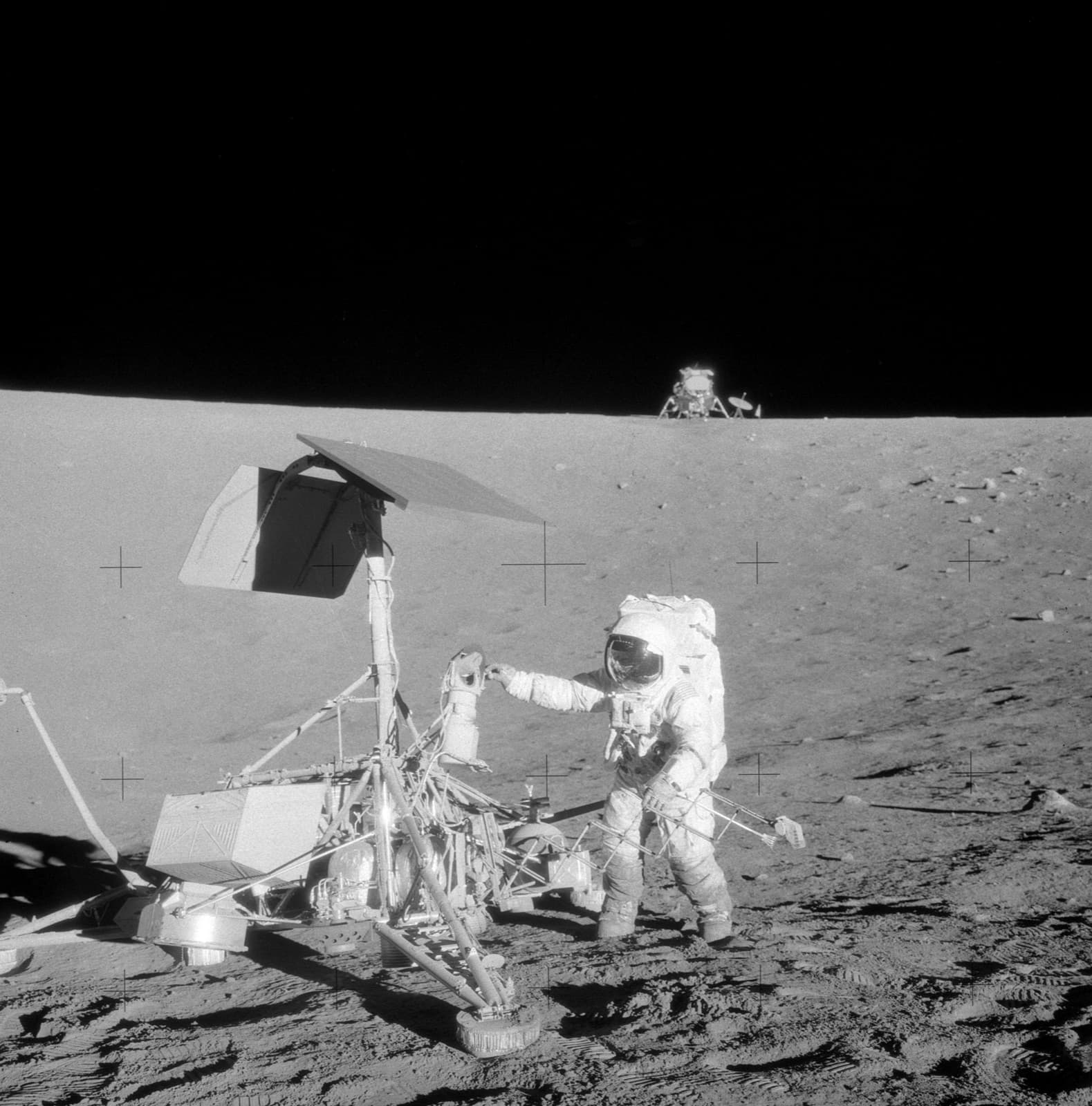 Photograph: Apollo 12 commander Pete Conrad at Surveyor 3, which had stood in Oceanus Procellarum since April 1967, with the lunar module Intrepid on the skyline behind, November 1969 (frame AS12-48-7133, taken by Alan Bean)