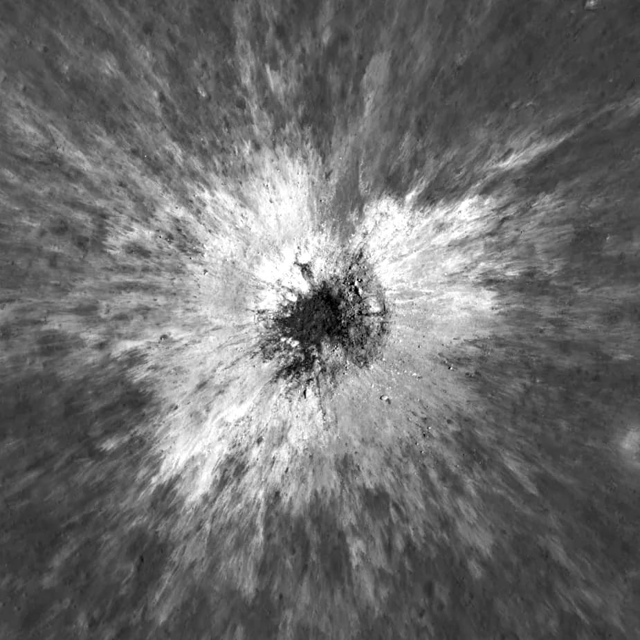 The same patch of ground on 25 December 2025: a dark crater at the centre surrounded by bright ejecta streaking outward in every direction