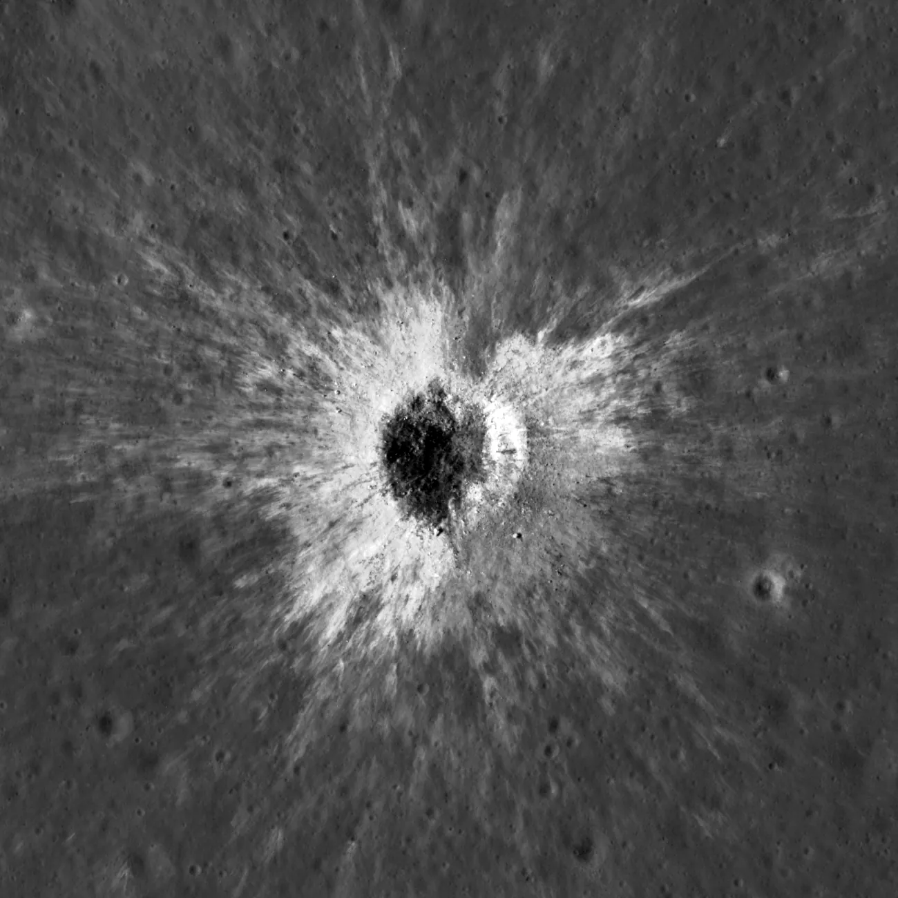 McGetchin crater from directly above: a dark crater interior ringed by bright ejecta that streaks outward across grey ground